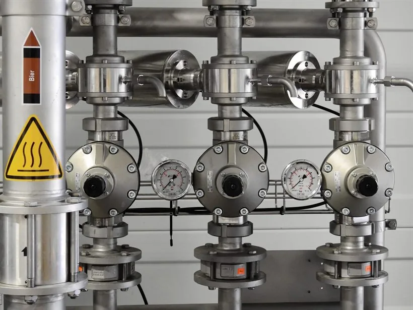 Painel com três conjuntos de válvula em aço inox, cada um com seu manômetro.